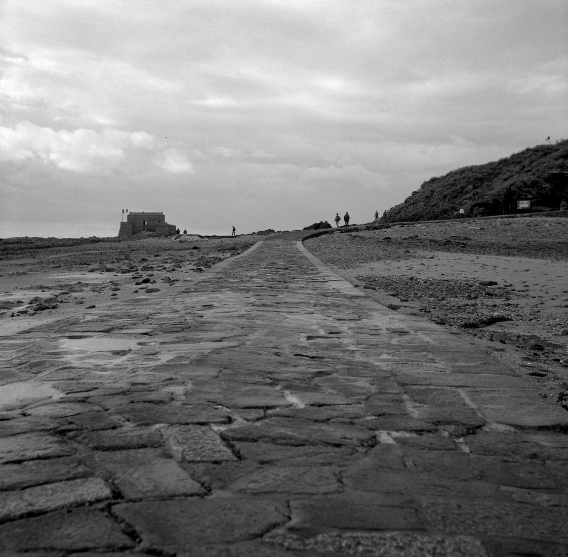 Au chemin, photographie argentique noir et blanc d’un chemin de pierre vers l’horizon